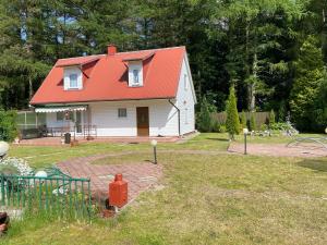 ein kleines weißes Haus mit orangefarbenem Dach in der Unterkunft Domek na Kaszubach in Bieszkowice