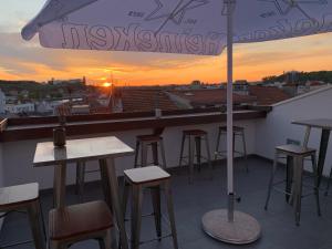 - un bar sur le toit avec des tables, des chaises et un parasol dans l'établissement Pharmacia GuestHouse, à Coimbra