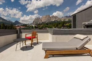 - Balcón con cama, mesa y silla en Grand Hotel Savoia Cortina d'Ampezzo, A Radisson Collection Hotel, en Cortina dʼAmpezzo