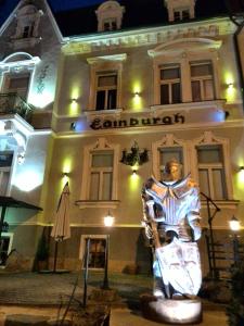 una estatua delante de un edificio por la noche en Edinburgh, en Mariánské Lázně