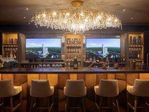 un bar con lampadario pendente e vista sulla città di Swissotel Santa Cruz de La Sierra a Santa Cruz de la Sierra