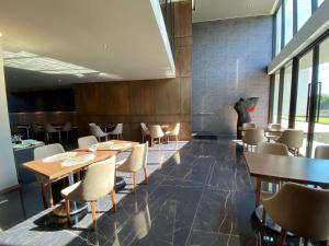 una sala da pranzo con tavoli e sedie in legno di Swissotel Santa Cruz de La Sierra a Santa Cruz de la Sierra