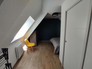 瑟堡Appartement 5 Cherbourg centre avec NETFLIX et WIFI的阁楼间 - 带黄色椅子和床