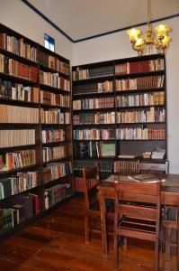 Eine Bibliothek mit einem Tisch und einem Haufen Bücher in der Unterkunft Pouso, Café e Cultura in Pirenópolis