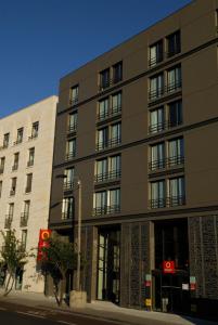 un grand bâtiment situé dans une rue de la ville à côté d'un bâtiment dans l'établissement Aparthotel Adagio Bordeaux Centre Gambetta, à Bordeaux