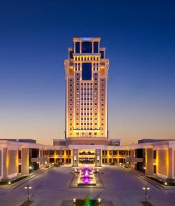 een groot gebouw met veel licht erop bij Divan Erbil Hotel in Erbil