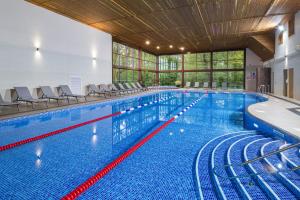 - une grande piscine avec des chaises dans un grand bâtiment dans l'établissement Woodbury Park Hotel & Spa, à Exeter