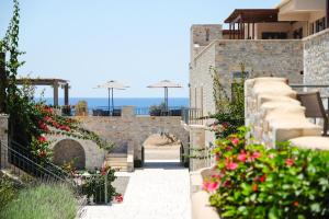 a patio with flowers on the side of a building at Margo Beach Hotel in Gythio