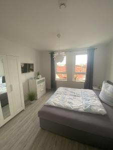 1 dormitorio con 1 cama, vestidor y 2 ventanas en Apartment Am Grünen Park, en Erfurt