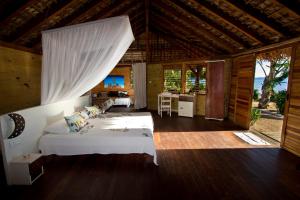 een slaapkamer met 2 bedden in een kamer met een keuken bij Anjiamarango Beach Resort in Nosy Be