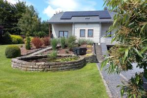 a house with solar panels on top of a garden at Bonheur à la campagne in Bastogne