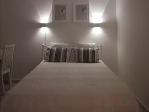 una camera da letto con un letto con due cuscini e due luci di Luxury Townhouse a Larisa