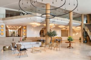 een lobby met een grote kroonluchter en tafels en stoelen bij Arrecife Gran Hotel & Spa in Arrecife