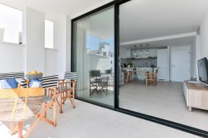 sala de estar con puertas correderas de cristal y comedor en ECO-APARTMENTS LA MARINEDA, en Roses