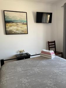 a bedroom with a bed and a painting on the wall at Vina's Place in Nazaré