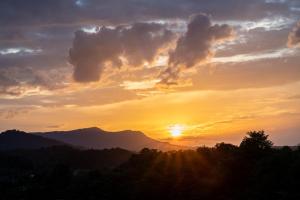 una puesta de sol en las montañas con la puesta de sol en The Lodge at Camp Margaritaville, en Pigeon Forge