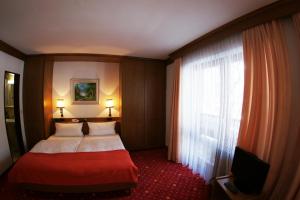 Habitación de hotel con cama y ventana en Hotel St. Georg, en Bad Reichenhall