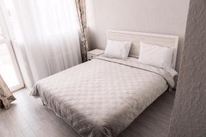 a white bed with two pillows in a bedroom at Отель-ресторан “Le Grand” in Zhytomyr