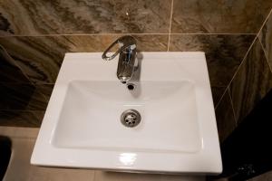 a white sink with a faucet in a bathroom at Отель-ресторан “Le Grand” in Zhytomyr