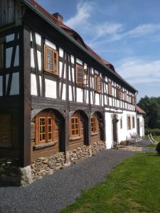 - un bâtiment noir et blanc avec fenêtres et pelouse dans l'établissement Izerski dom, à Leśna