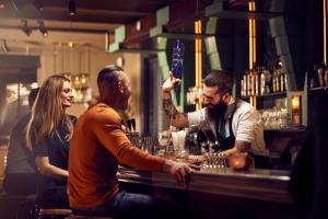 um grupo de pessoas sentadas num bar em Hotel New York by WestCord em Roterdão