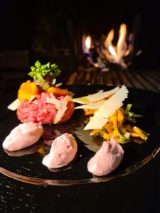 un piatto di cibo con carne e formaggio su un tavolo di A' la Table du Sommelier Chambres d Hôtes & Restaurant a Saint Vincent