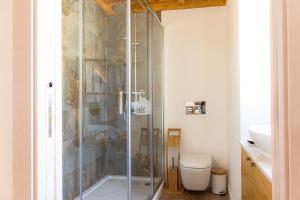 a glass shower in a bathroom with a toilet at Casa Marmelos - Alojamento Local in Ourém