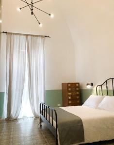 een slaapkamer met een bed en een groot raam bij Caves Apartment in Bari