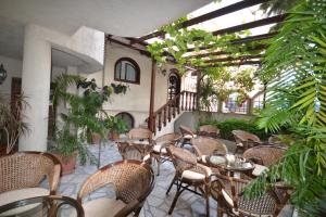 an outdoor patio with tables and chairs and plants at Семеен Хотел Море in Sozopol