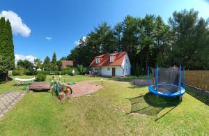 einen Hof mit einem Spielplatz und einem Haus in der Unterkunft Domek na Kaszubach in Bieszkowice