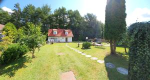 einen Hof mit einem Haus mit einem Baum davor in der Unterkunft Domek na Kaszubach in Bieszkowice