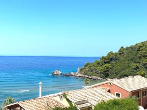 una spiaggia con una casa rosa e l'oceano di Corfu, Glyfada, Sea la vie apartment a Glifada (Glyfada)