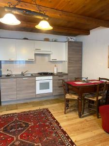 a kitchen and dining room with a table and a stove at Frazione Duc Apartments in Sestriere