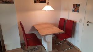 uma mesa e quatro cadeiras vermelhas num quarto em Ferienwohnung sunset Weissenstadt em Weißenstadt