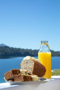 um pedaço de pão e uma garrafa de sumo de laranja em Costa Serena Apart Cabañas & Spa em Villa La Angostura