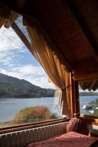 uma janela num quarto com vista para um lago em Costa Serena Apart Cabañas & Spa em Villa La Angostura