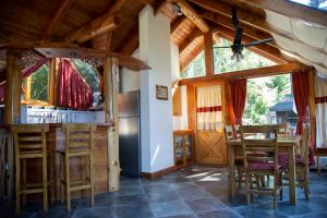 uma cozinha e sala de jantar com mesa e cadeiras em Costa Serena Apart Cabañas & Spa em Villa La Angostura