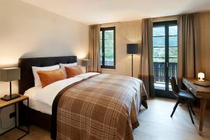 una camera con letto, scrivania e finestre di Eiger View Alpine Lodge a Grindelwald