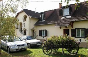 una casa con due auto parcheggiate nel cortile di Zöldvár villa a Bogács