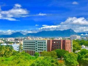 a view of a city with mountains in the background at Welcomhotel by ITC Hotels, RaceCourse, Coimbatore in Coimbatore