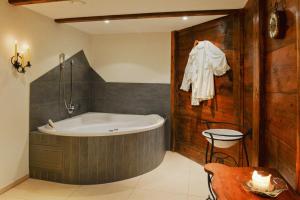 ein Badezimmer mit einer Badewanne, einem Tisch und einem Stuhl in der Unterkunft Hotel Viktoria Eden in Adelboden