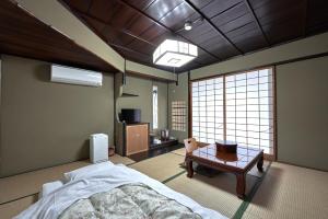 Habitación con cama y mesa. en Ryokan Yamamuro, en Kanazawa