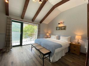 ein Schlafzimmer mit einem großen Bett und einem großen Fenster in der Unterkunft Black Sheep Hotels Cabins in Spean Bridge