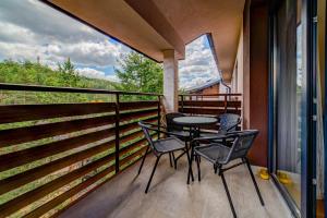 a balcony with a table and chairs on it at Vila Pekovic, Pine Trees View Apartment with big balcony in The Center of Zlatibor! in Zlatibor