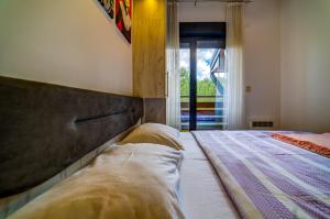 a bedroom with a large bed and a window at Vila Pekovic, Pine Trees View Apartment with big balcony in The Center of Zlatibor! in Zlatibor