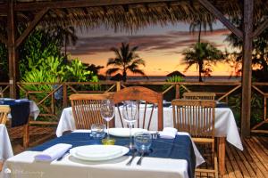 - une table avec des assiettes et des verres à vin au-dessus d'un restaurant dans l'établissement Hotel Océan Beach Sakatia, à Nosy Be