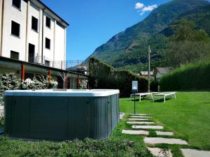 un edificio con un banco en un patio con montañas en Hotel Diana Jardin et Spa, en Aosta