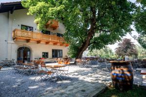 eine Terrasse mit Tischen und Stühlen vor einem Gebäude in der Unterkunft Bergwirt Hotel & Gasthof in Kiefersfelden