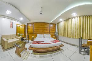 sypialnia z łóżkiem, kanapą i krzesłem w obiekcie Hotel Radiant w mieście Kolhapur