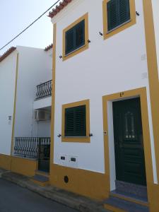 un edificio bianco con una porta nera e un balcone di Refúgio d' Aldeia a Reguengos de Monsaraz